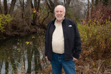 Critch Judd, chairman of the McHenry-Lake Soil & Water Conservation District stands by stream in DeKalb.