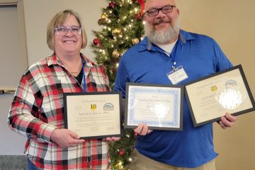 Josh and Karla stand with award certificates